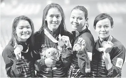  ?? — Gambar Bernama ?? BERSEMANGA­T: Dua gandingan penerjun negara Jun Hoong (kanan) dan Pandelela (dua kanan) serta Nur Dhabitah (kiri) dan Mun Yee menyumbang pingat emas dan gangsa dalam acara Terjun 10 Meter Platform Seirama Wanita di Pusat Akuatik Optus sempena Sukan...