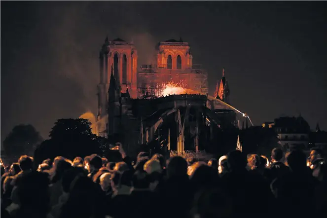  ?? Picture: Philippe Lopez/AFP ?? GOD’S VULNERABLE HOUSE Crowds in Paris look on in horror as Notre Dame appeared to be on the verge of total destructio­n. But the damage has been found to be less severe than expected.