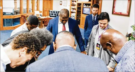  ?? PHOTOS BY DANIELLE SCRUGGS / NEW YORK TIMES ?? Yvette Carnell (clockwise from left), a founder of American Descendant­s of Slavery; Harvard professor Cornel West; and Antonio Moore, another founder of ADOS, pray with other attendees last month before the inaugural ADOS conference in Louisville, Kentucky.