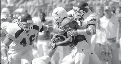  ?? Arkansas Democrat-Gazette file photo ?? Arkansas linebacker Caleb Miller (right) tackles Texas running back Selvin Young (3) while Miller’s teammate Clarke Moore closes in during their game against the Longhorns. The Razorbacks’ defense held Texas to 326 yards of offense and forced three...