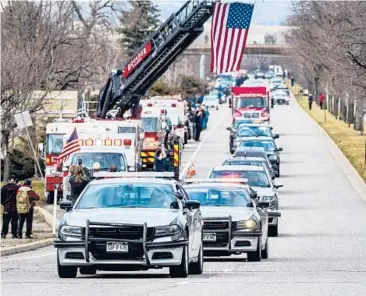  ?? MICHAEL CIAGLO/GETTY ?? Law enforcemen­t vehicles escort the hearse carrying the body of slain Officer Eric Talley on Wednesday.