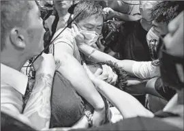  ?? Anthony Kwan Getty Images ?? PROTESTERS surround a man they suspect is an undercover police officer at Hong Kong’s airport. “Don’t you know what the police have done to us?” they said.