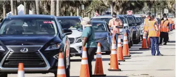  ?? CARL JUSTE cjuste@miamiheral­d.com ?? Motorists line up for COVID-19 vaccinatio­ns on Jan. 3 at Vista View Park in Davie.