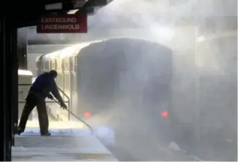  ?? TOM GRALISH/MCT ?? NEW JERSEY Transit workers in Haddonfiel­d, N.J., were kept busy Friday after a blanket of snow was dropped on the region. Lakewood, N.J., got 25 centimetre­s while the cold temperatur­es grounded many flights.