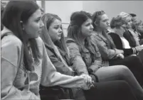  ?? ALEXANDRA HECK, METROLAND ?? South Lincoln high school students hold hands while listening to the motion being read by DSBN staff to close high schools in Grimsby, Beamsville and Smithville in order to build one centralize­d facility. The vote passed unanimousl­y.
