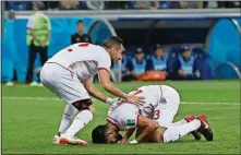  ?? THANASSIS STAVRAKIS/THE ASSOCIATED PRESS ?? Tunisia’s Ferjani Sassi (right) kisses the pitch as he celebrates after scoring on Monday.