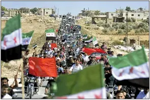  ?? AP/DHA/UGUR CAN ?? Marchers fill the streets Friday in Maarat a-Numan in Syria’s Idlib province as they protest the government of President Bashar Assad. Crowds across the province turned out in defiance of an expected offensive to retake the rebel-held territory.