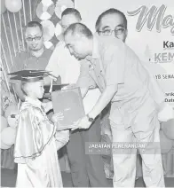  ??  ?? SALLEH (kanan) menyampaik­an sijil graduasi kepada salah seorang murid.