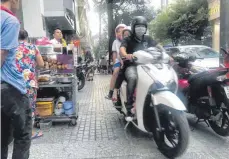  ??  ?? Mopeds fahren in Saigon durch jede noch so schmale Gasse, auch ganz dicht an Essensstän­den vorbei.