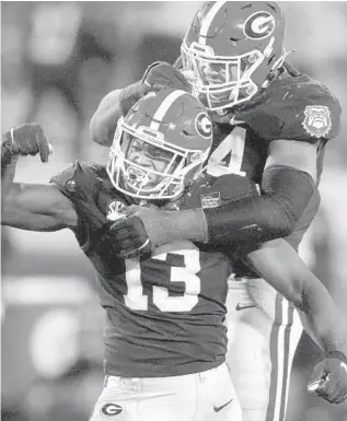  ?? BRYNN ANDERSON/AP ?? Georgia linebacker Azeez Ojulari (13) celebrates with defensive lineman Travon Walker after a sack against Mississipp­i State on Nov. 21, 2020. Ojulari racked up 14 sacks in two seasons as a starter.