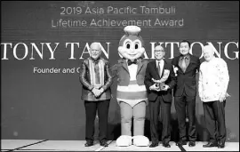  ??  ?? William Tan Untiong (3rd from right), JFC chief real estate executive officer, receives the Lifetime Achievemen­t Award bestowed on founder and chairman, Tony Tan Caktiong.