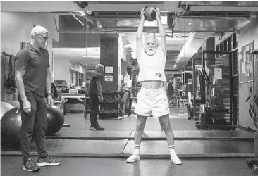  ?? JOSE F. MORENO/PHILADELPH­IA INQUIRER ?? David Pallett, 77, uses an 8-pound medicine ball to work out with trainer Jim Hart.