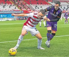  ??  ?? Lee Hodson holds up Dundee United’s Lawrence Shankland at the FOY Stadium last month