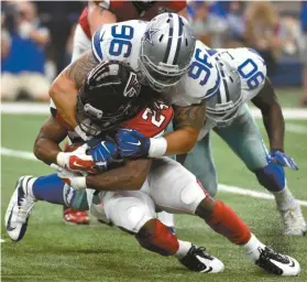  ?? Michael Ainsworth/AP ?? Atlanta Falcons running back Devonta Freeman (24) is stopped on a running play by Dallas Cowboys’ Nick Hayden (96) in the first half of an NFL football game on Sunday, Sept. 27, 2015, in Arlington, Texas.