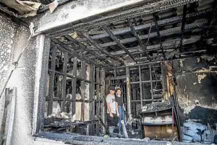  ?? BRADEN FASTIER/STUFF ?? Sian Kerr and Simon Rees look around the remains of their home after it was gutted by a fire on Thursday. The couple say they have been ‘‘completely overwhelme­d’’ by the support they have received from the community and the Stoke Volunteer Fire Brigade, of which Rees is a member.