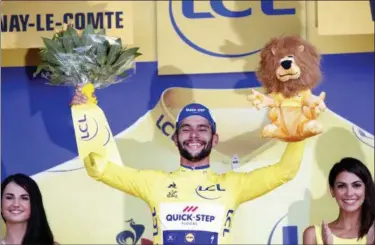  ?? CHRISTOPHE ENA — THE ASSOCIATED PRESS ?? Stage winner and new overall leader Fernando Gaviria of Colombia celebrates on the podium after the first stage of the Tour de France cycling race over 201 kilometers (124.9 miles) with start in Noirmoutie­r-en-L’Ile and finish in Fontenay Le-Comte,...