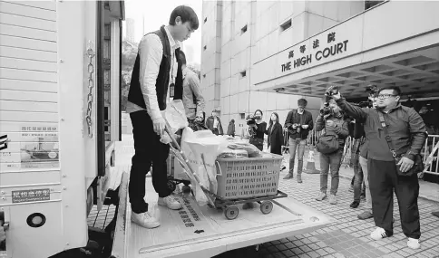  ??  ?? Policemen deliver evidence relating to rioting charges to the High Court in Hong Kong, China. — Reuters photo