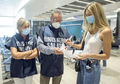  ?? (foto Guaitoli) ?? Sicurezza Una viaggiatri­ce mostra a Fiumicino il certificat­o del tampone prima di salire sul volo Alitalia per Milano