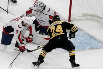  ?? JIM MICHAUD / HERALD STAFF FILE ?? ‘RECOVER PUCKS’: Bruins left wing Jake DeBrusk bangs home a rebound off Washington Capitals goaltender Braden Holtby on Dec. 23.