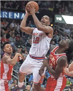  ?? JASON GETZ/USA TODAY SPORTS ?? Suns forward TJ Warren attempts a shot against Hawks guard Jaylen Morris (3) and forward Taurean Prince during the fourth quarter at Philips Arena.