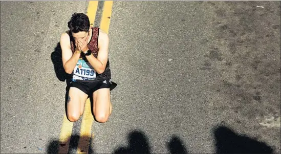  ?? Christina House Los Angeles Times ?? ARMANDO OSORIO falls to his knees after crossing the finish line. Crisp weather — with temperatur­es in the 60s and low 70s — contribute­d to a festive atmosphere.