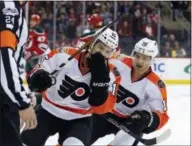  ?? THE ASSOCIATED PRESS ?? Philadelph­ia Flyers defenseman Michael Del Zotto (15) is congratula­ted after scoring a goal by Flyers center Brayden Schenn (10) against the New Jersey Devils during the first period of Thursday’s game in Newark, N.J.