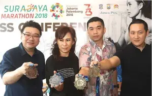  ?? GHOFUUR EKA/JAWA POS ?? UKIRAN IKON: Dari kiri, Sutandi Purnomosid­i, Fransisca M. Budiman, Nelwin Holing, dan Ng Willy Widjaja menunjukka­n medali tiap kategori Surabaya Marathon 2018 Kamis lalu (2/8).