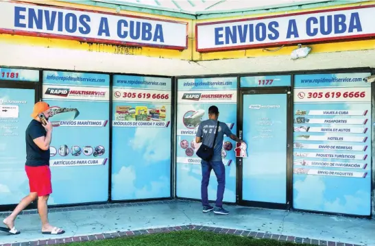  ?? EFE ?? Dos personas frente a una tienda de envíos y remesas a Cuba en el barrio de Hialeah, en Miami, Florida