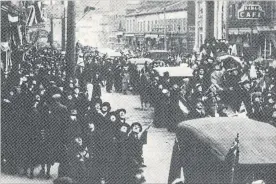  ?? ST. CATHARINES MUSEUM ?? The city crowds into the street, milling about St. Paul Street just west of James, looking skyward as an airplane circles above them.