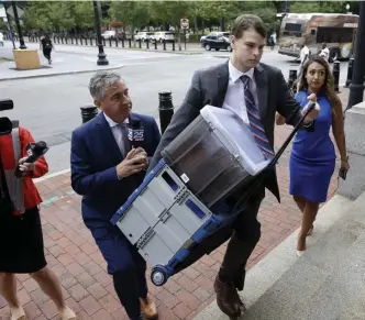  ?? AP ?? COURTHOUSE QUESTIONS: Nathan Carman, center, pursued by TV crews, carries documents as he arrives at federal court Tuesday in Providence, R.I.