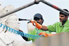  ??  ?? Clean as new: workers spruce up an 1897 statue of Queen Victoria in Colombo, Sri Lanka