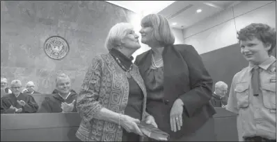  ?? Arkansas Democrat-Gazette/MELISSA SUE GERRITS ?? Patricia Harris (center) leans in for a kiss on the cheek from her mother, Patricia Newton, while joined by her son, Scott, during a ceremony for Patricia Harris’ investitur­e as a U.S. magistrate judge Friday at the federal courthouse in Little Rock.