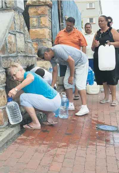  ?? Picture: AFP ?? DRINKING HOLE. Residents collect water from pipes fed by an undergroun­d spring in St James, about 25km from the Cape Town city centre, on Monday as the city battles its worst drought in a century. Good news, though, is that Day Zero has been moved to...