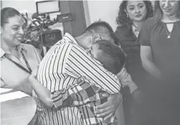  ??  ?? Patricia Marroquin (right), the first lady of Guatemala, watches as a family is reunited at the shelter in Guatemala City on Tuesday.