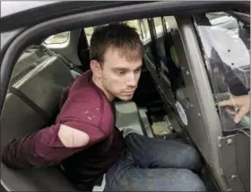  ?? METRO NASHVILLE POLICE DEPARTMENT VIA AP ?? In this photo released by the Metro Nashville Police Department, Travis Reinking sits in a police car after being arrested in Nashville, Tenn., on Monday. Police said Reinking opened fire at a Waffle House early Sunday, killing at least four people.