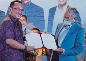  ?? (Foto Sharul Hafiz ZAM/BH) ?? Dr Mahathir menyerahka­n watikah pelantikan Khusyairi di Slim River, malam tadi. calon Bebas kepada Amir