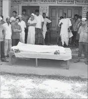  ?? Associated Press ?? MEN SURROUND the body of Nityaranja­n Pandey, who was attacked in the Pabna district of Bangladesh.