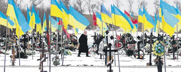  ?? ?? An elderly woman walks among the graves along the Alley of Heroes where Ukrainian soldiers who died in the Russia-Ukraine war are buried, Kramatorsk, Donetsk region, Ukraine, Feb. 22, 2024.