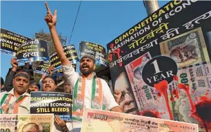  ?? AFP ?? Congress party supporters shout slogans as they hold placards during a protest on the eve of the first anniversar­y of demonetisa­tion scheme in Mumbai on Tuesday. —