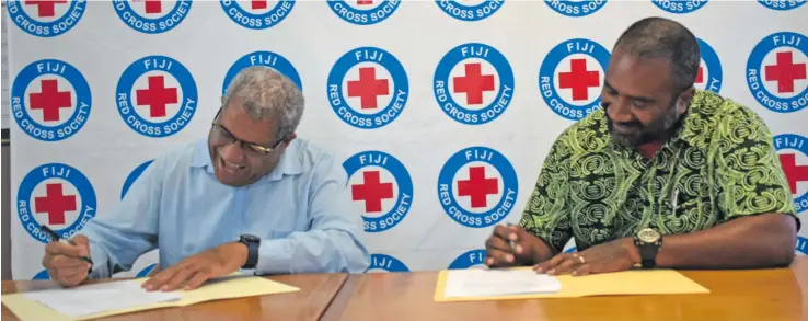  ??  ?? The signing of the Memorandum of Understand­ing between Fiji Red Cross Society director general Filipe Nainoca (left), and the Ola Fou (Fiji) Trust organisati­on manager Amani Waqetia.