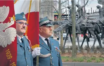  ?? CHRIS CHRISTO / HERALD STAFF FILE ?? HEROIC: Witold Blicharski, left, of New Britain, Conn., and Zdzislaw Makarewicz of South Boston stand as part of the color guard Saturday during the rededicati­on of the Polish Partisans sculpture in the Seaport.