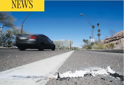  ?? CHRIS CARLSON / THE ASSOCIATED PRESS ?? Cars pass the scene in Tempe, Ariz., close to where a pedestrian was struck by an Uber vehicle Sunday night. The vehicle was in autonomous mode with an operator behind the wheel when the woman was hit. Uber suspended all of its self-driving testing...