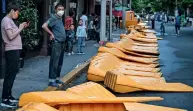  ?? People stand next ?? Ted Sams receives his original high school diploma to barriers, ERECTED ON MARCH 19 AS PART OF LOCKDOWNS IN THE AREA AND TAKEN DOWN IN THE JING’AN DISTRICT OF SHANGHAI ON TUESDAY. — afp