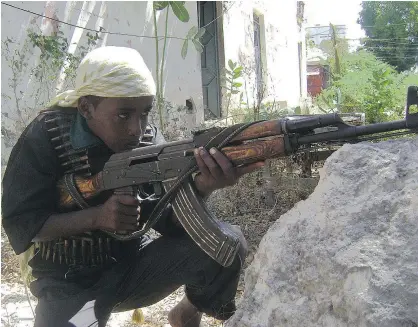  ?? — GETTY IMAGES FILES ?? An young Islamic fighter aims his gun during a training exercise in Somalia. Canada is expected to approve new comprehens­ive guidelines on dealing with child soldiers.