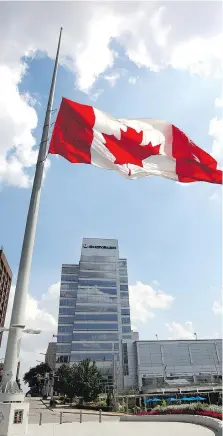  ?? PHOTOS: NICK BRANCACCIO ?? The Great Canadian Flag flies at half-staff in front of FCA Canada headquarte­rs at One Riverside Drive West Wednesday following the death of longtime FCA CEO Sergio Marchionne.