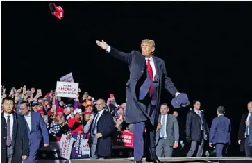  ?? Alex Brandon Associated Press ?? PRESIDENT TRUMP throws hats into the crowd Wednesday at a rally in Duluth, Minn. A new timeline of his COVID-19 case, if accurate, would mean he held that event and a fundraiser while knowing he was sick.