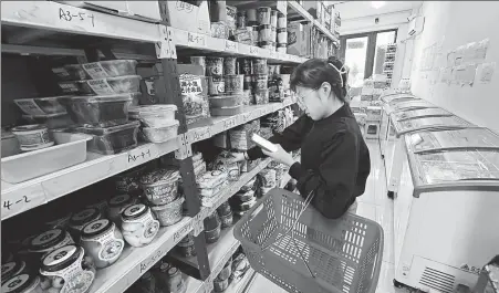  ?? ZHOU HUIYING / CHINA DAILY ?? A staff member prepares orders at a Feixiang Convenienc­e Store in Harbin, Heilongjia­ng province.