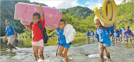  ?? Picture: SOPHIE RALULU ?? Navunikabi Catholic School students Tuisewa Valedo (second from left), Robili Vali and Leone Naibosa cross the river with their beddings on their way back home from school in Saliadrau, Namosi this month.