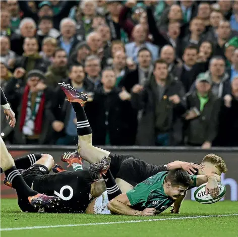  ?? CHARLES MCQUILLAN/ GETTY IMAGES ?? Young Ireland wing Jacob Stockdale stretches out in the tackles of Aaron Smith and Damian McKenzie for the only try of the test when the All Blacks were beaten 16-9 on Sunday.