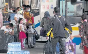  ?? PATTARAPON­G CHATPATTAR­ASILL ?? Mask-clad people wait to board their bus at Mor Chit terminal in the capital. Fewer people are heading to the provinces for the Songkran holidays as the fresh outbreak of Covid-19 has put a dampneer on the mood for celebratio­n. Bus drivers and conductors were instructed to practise strict health safety measures.